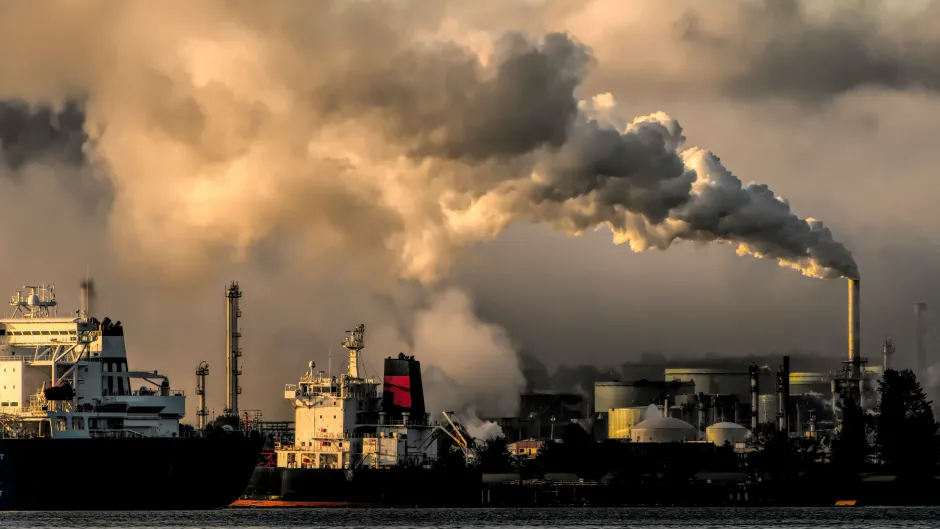 Hafen mit Industrieanlagen und dampfenden Schornsteinen